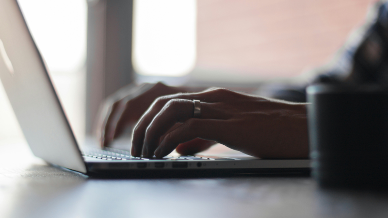 Close up of a person's hands typing on a laptop